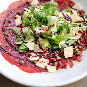Delicious beef carpaccio topped with arugula, capers, and shaved Parmesan, drizzled with balsamic glaze.